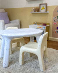 Children's playroom with a small table and chairs on a carpeted floor.