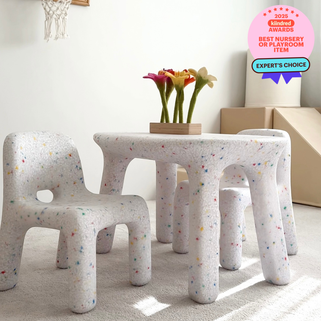 Children's table and chairs with a speckled design in a room with toys and a Kindred Awards badge.