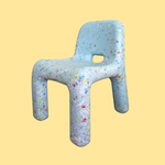 Children's chair with colorful speckles on a yellow background