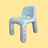 Children's chair with colorful speckles on a yellow background