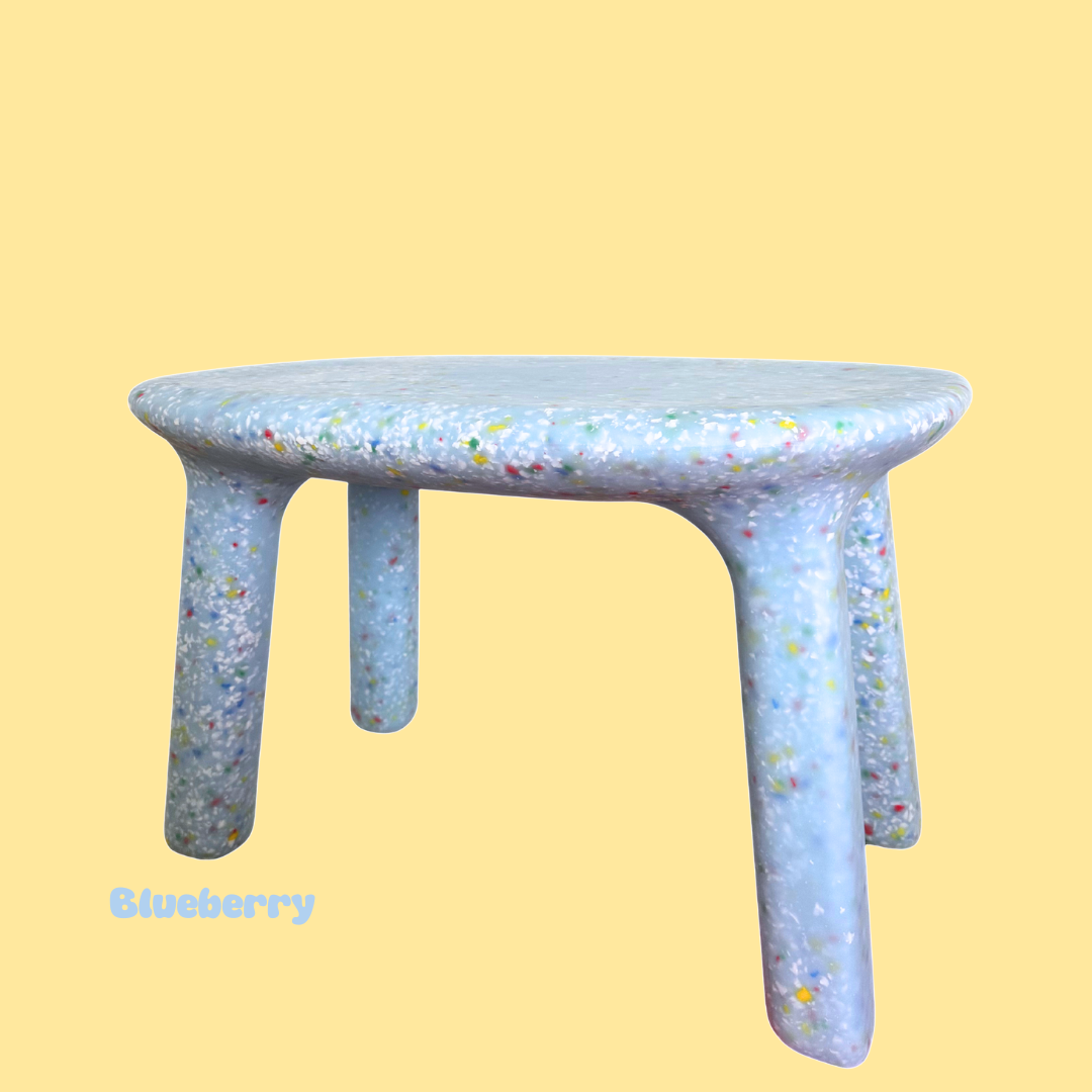 Three-legged table with a speckled design on a yellow background, labeled 'Blueberry'.