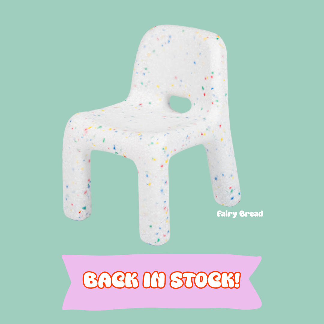 White chair-shaped pillow with colorful sprinkles on a light green background, featuring the brand 'Fairy Bread'.