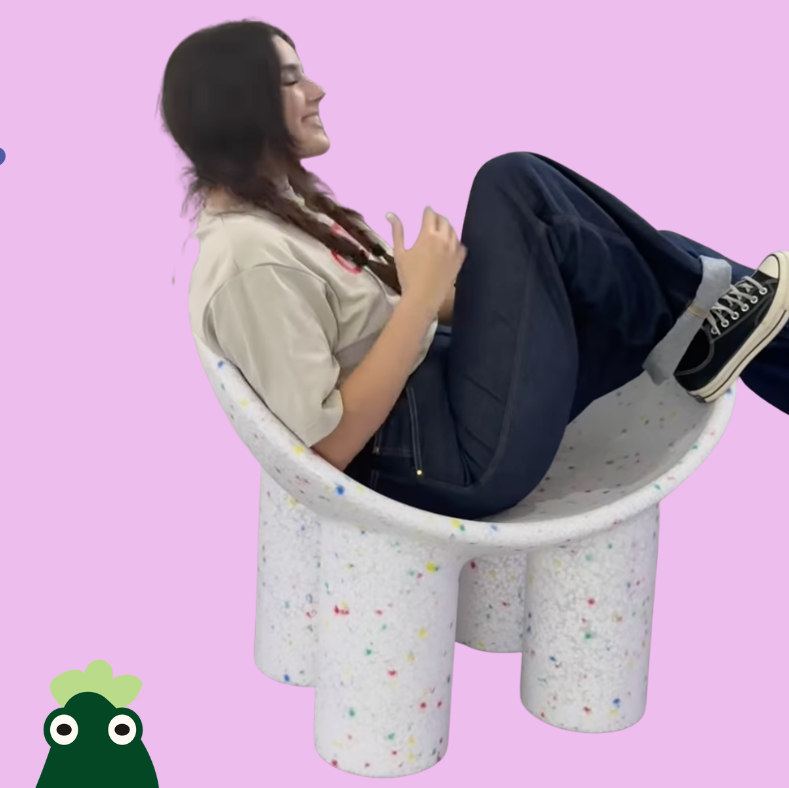 Person sitting on a colorful chair against a pink background with cartoon characters.