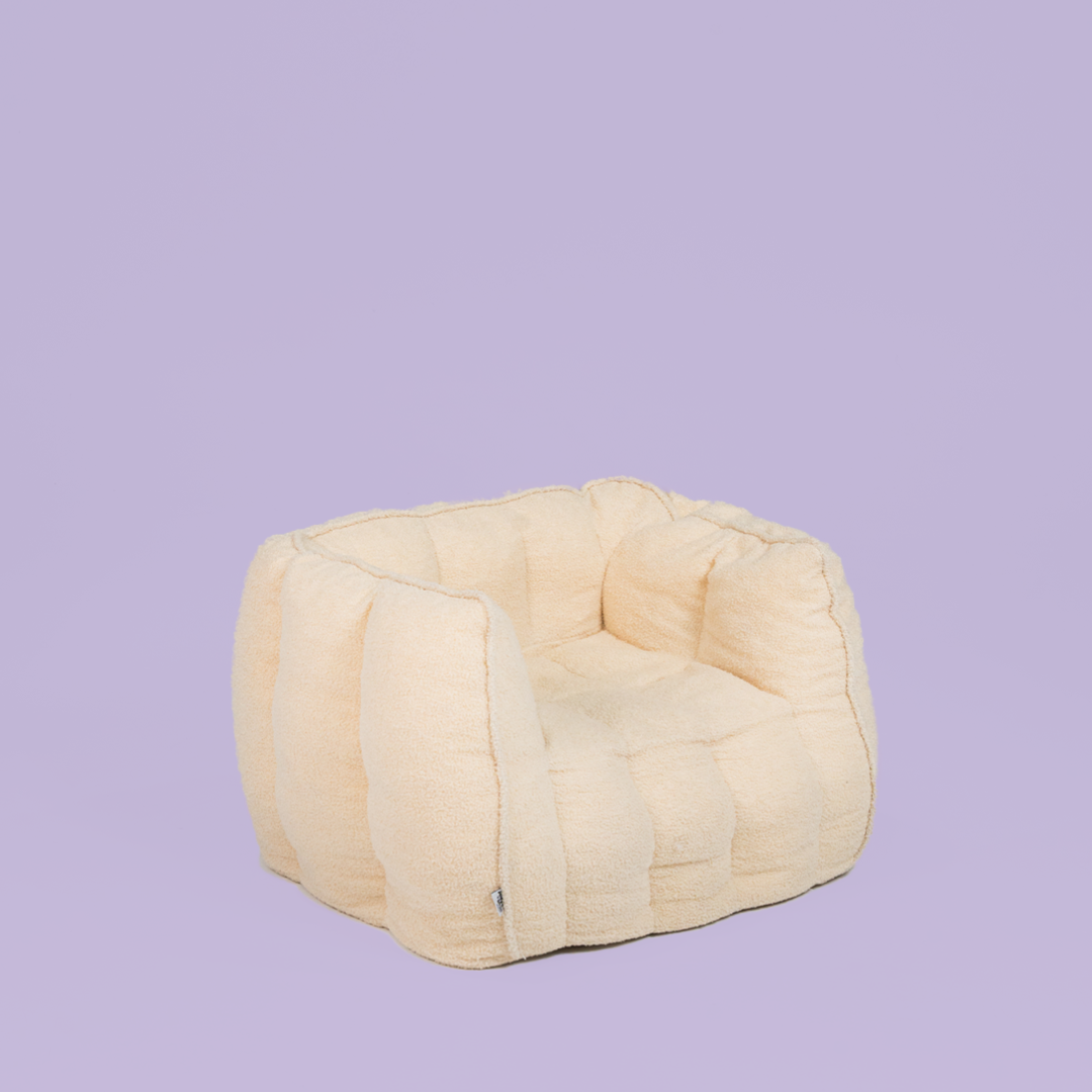 Beige bean bag chair on a purple background