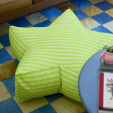 Green striped bean bag chair on a checkered floor with a small table and plant in the foreground.