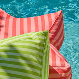 Striped cushions in red and green by a pool