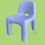 Purple chair with colorful speckles on a green background