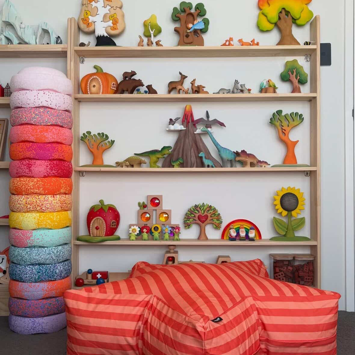 Children's room with colorful toys and a striped bean bag chair.