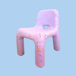 Colorful, textured chair-shaped object on a light blue background