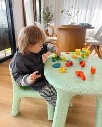 kid playing on mint confetti set