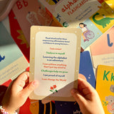 Person holding an alphabet flashcard with affirmations surrounded by more flashcards.