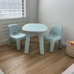 Children's table and chairs set on a wooden floor with baskets around.