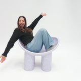 Person sitting on a unique chair with a white background