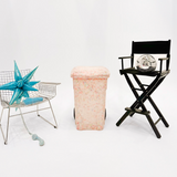Decorative items including a star-shaped object, a black director's chair with a decorative item, and a pink woven basket on a white background.