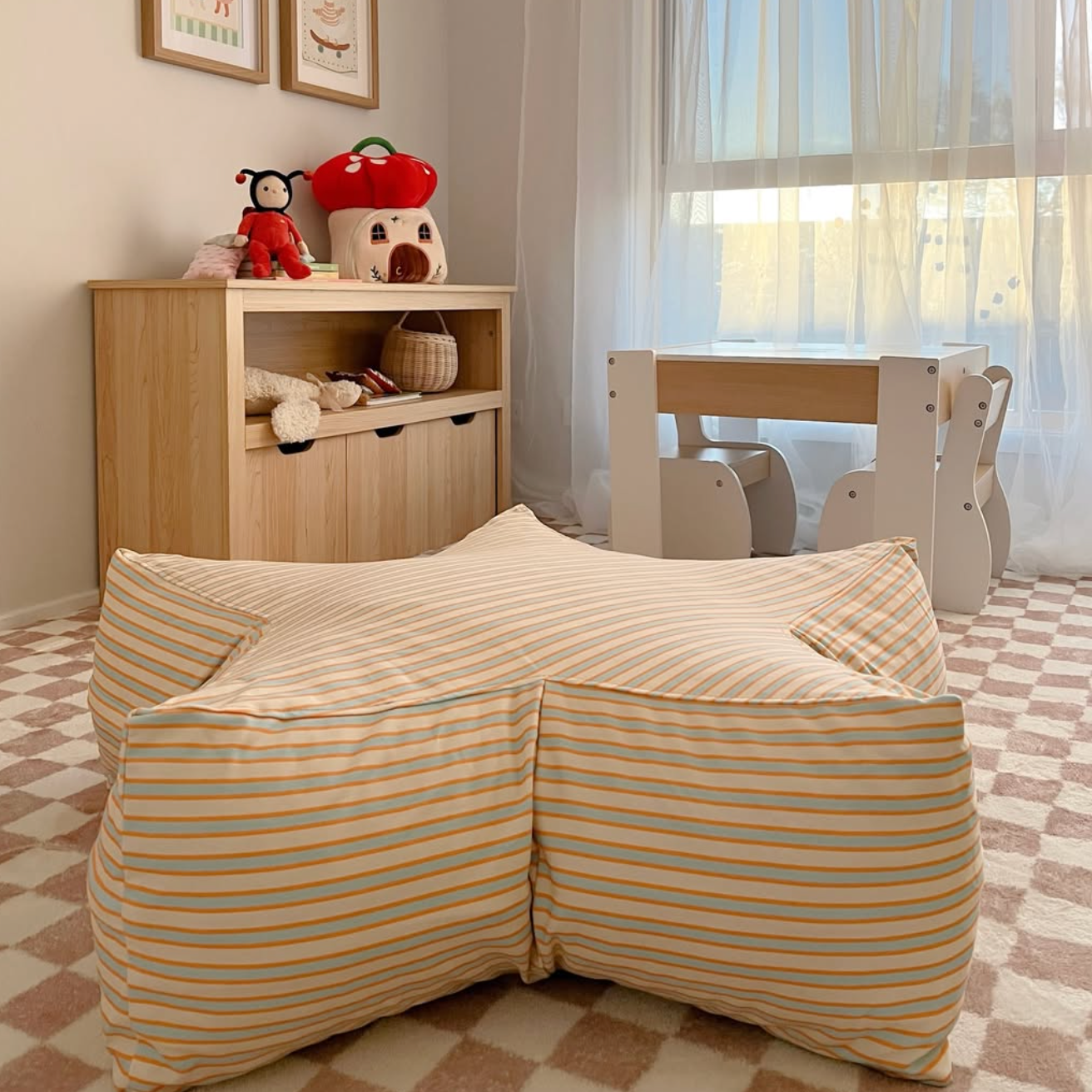 Children's room with striped bean bag, bookshelf, and toys.