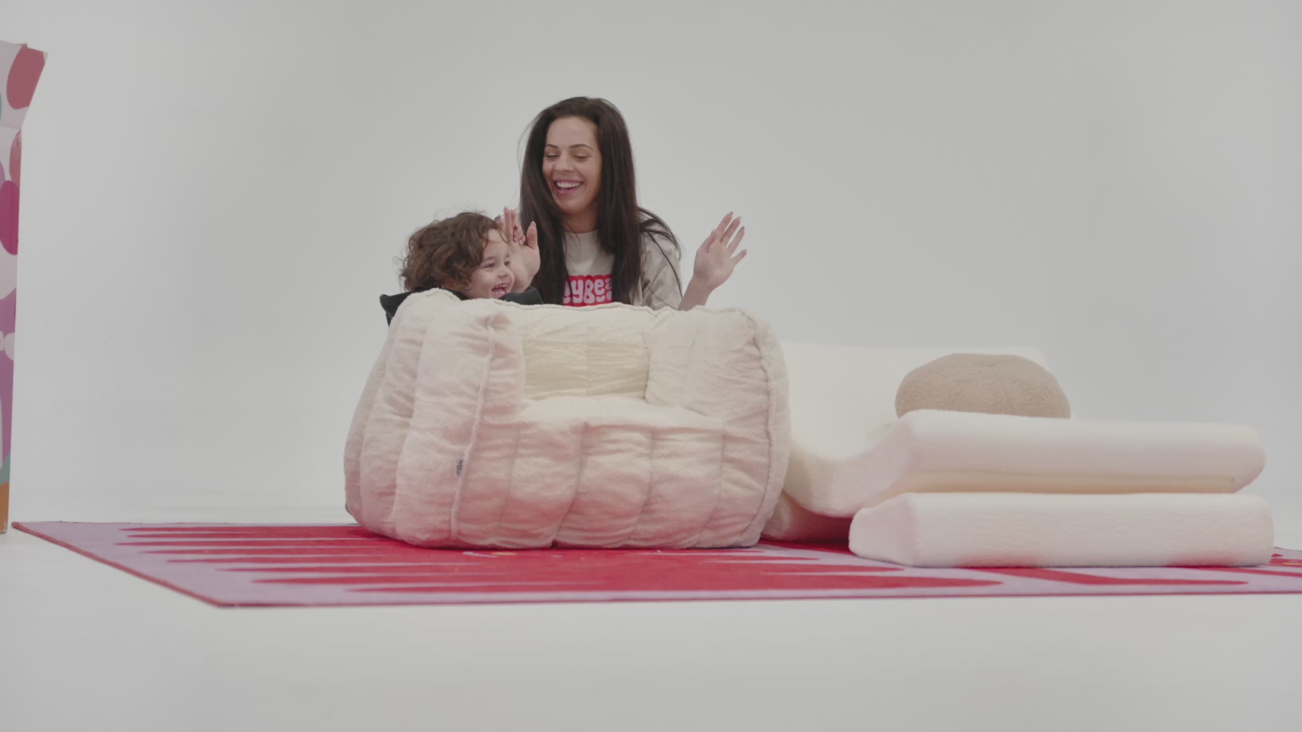 video of a little boy playing with little loungers, confetti chair and table with a women showing how much fun they are having