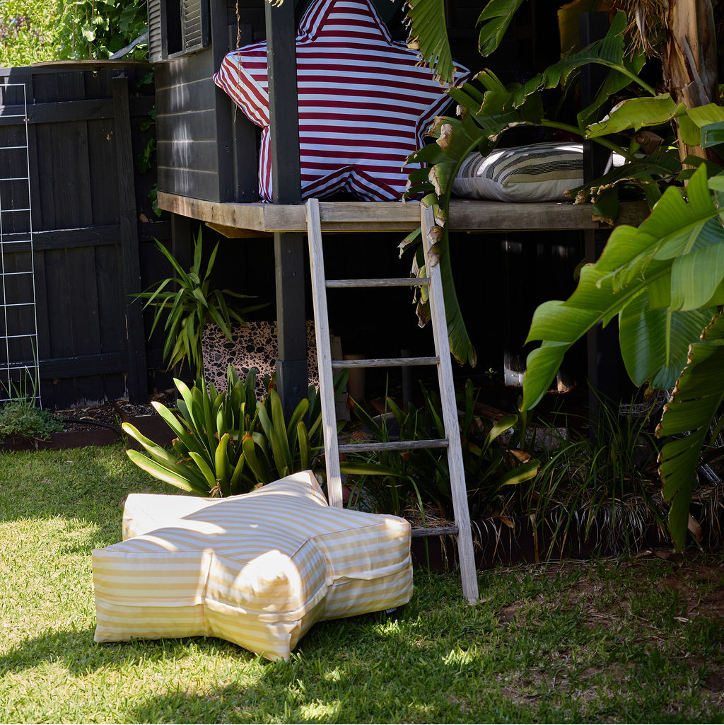 Outdoor setting with striped chair, table, and ottoman on grass